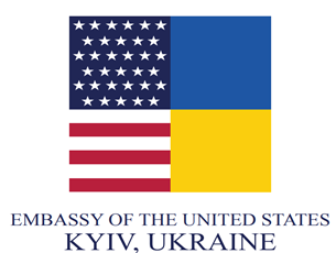 ASV vēstniecības Kijevā, Ukrainā, logotips ar kvadrātu, kurā apvienoti ASV karoga elementi (zvaigznes un svītras) ar Ukrainas karoga zilo un dzelteno krāsu. Zem tā ir šāds teksts: ASV VĒSTNIECĪBA KIJEVĀ, UKRAINĀ.